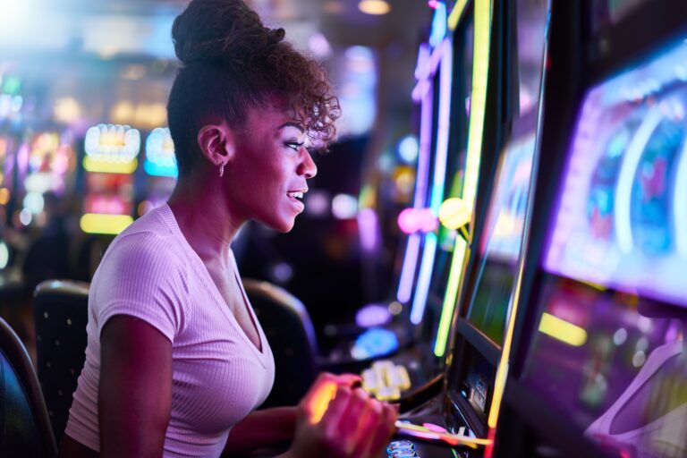 woman having fun playing slot machine at casino